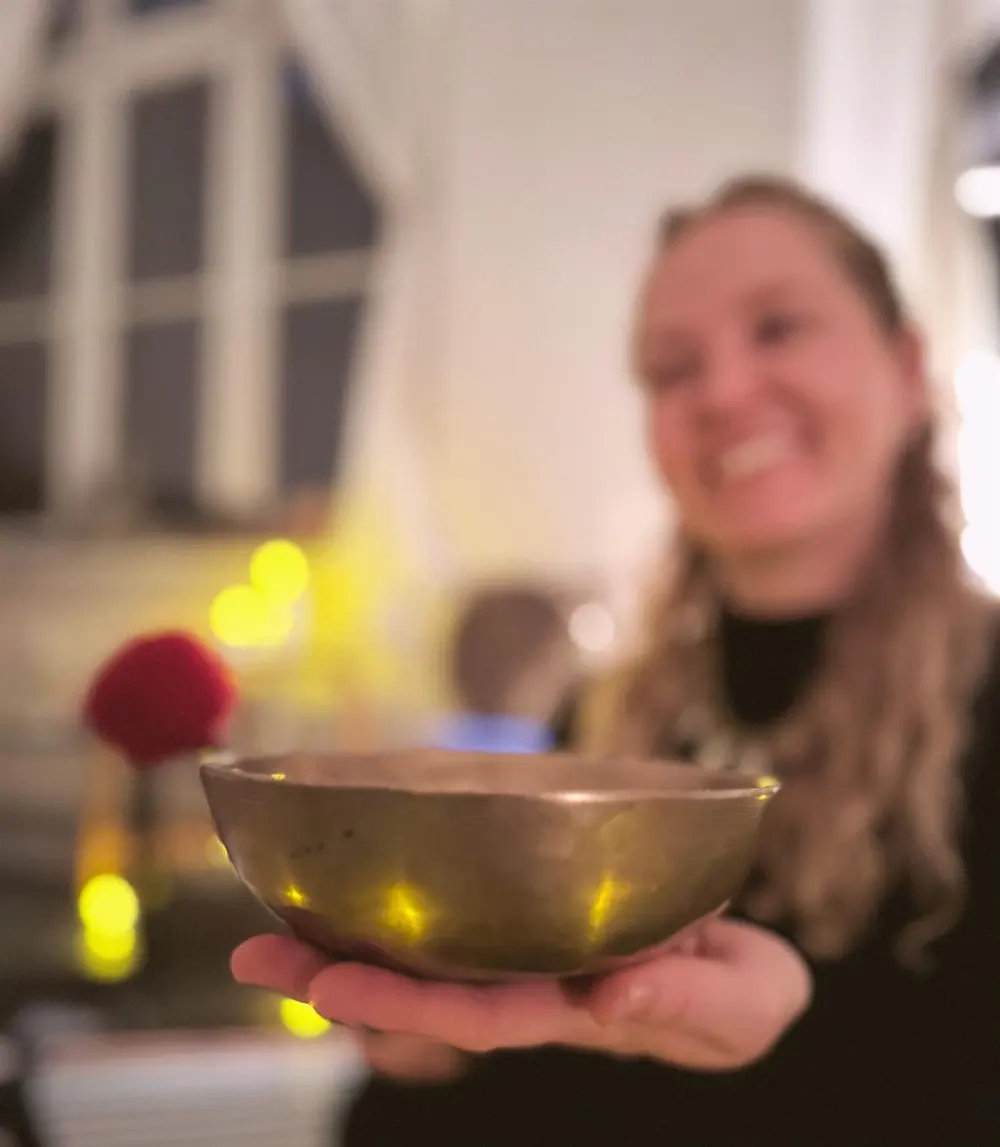 Anna reicht eine Klangschale entgegen